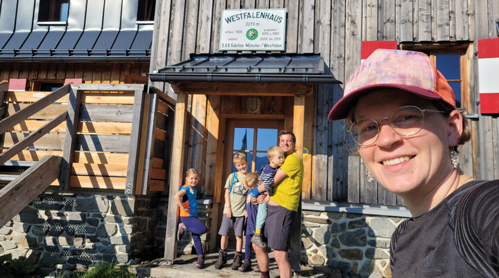 Es ist eine Familie mit mehreren Kindern vor dem Westfalenhaus zu sehen im Sonnenschein | © DAV Münster